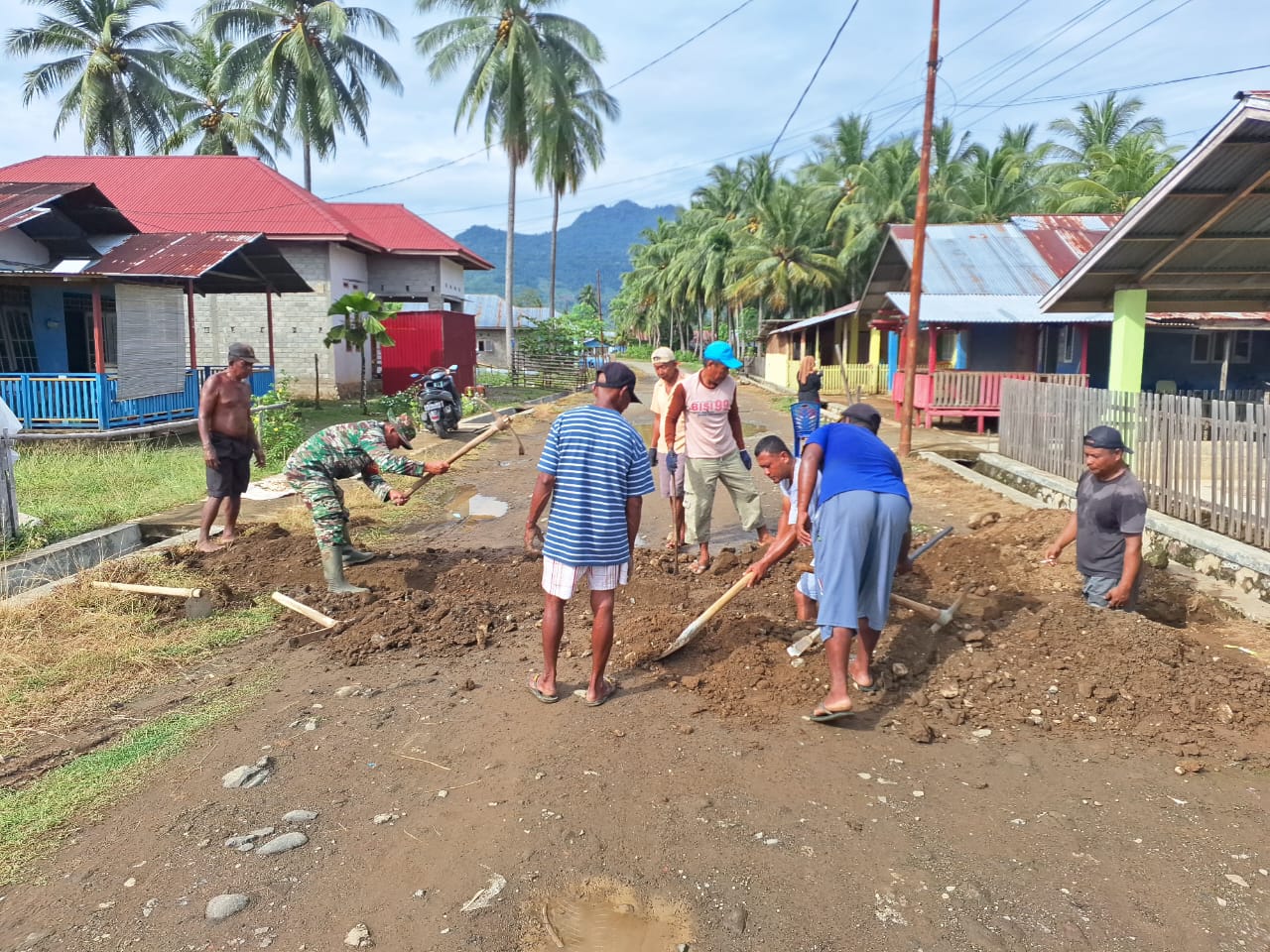 Warga dan Babinsa Koramil 1314-03/Sumalata bergotong royong menggali saluran air di jalan pasar Desa Bulontio Barat yang sebelumnya tergenang air hujan.